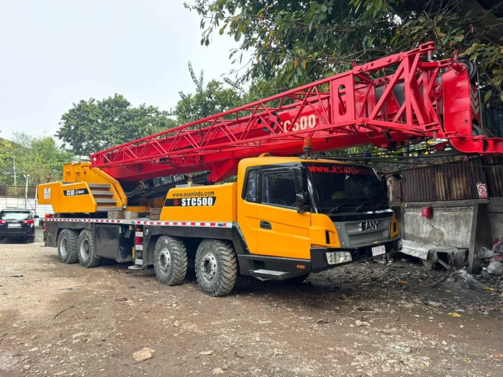 A 50-ton mobile crane is performing high-precision heavy lifting operations at a construction project site in Jabodetabek.