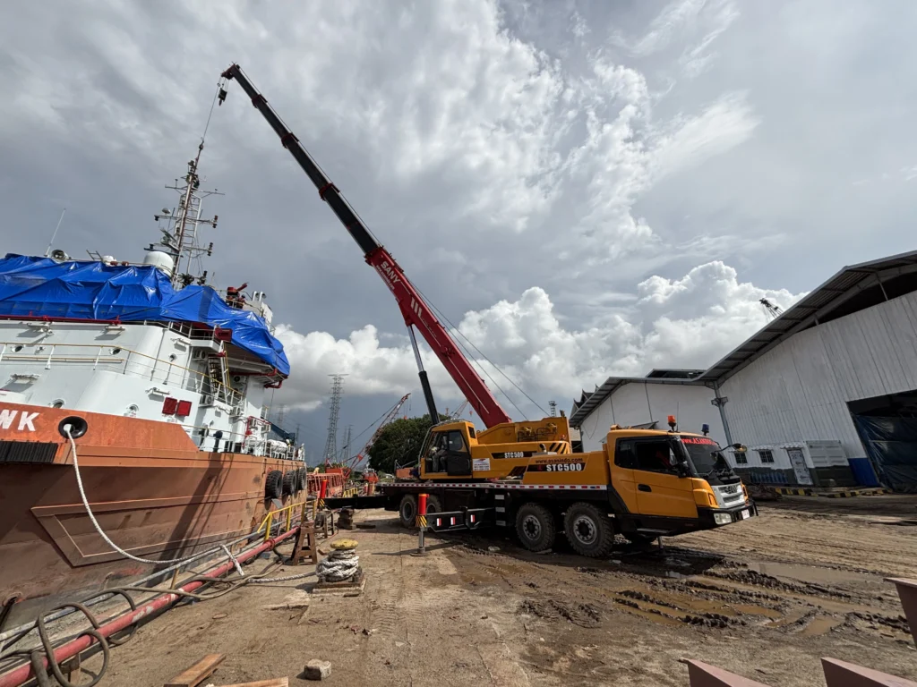 Mobile crane melakukan operasional bongkar muat kargo di dermaga pelabuhan Jakarta dengan standar keselamatan internasional