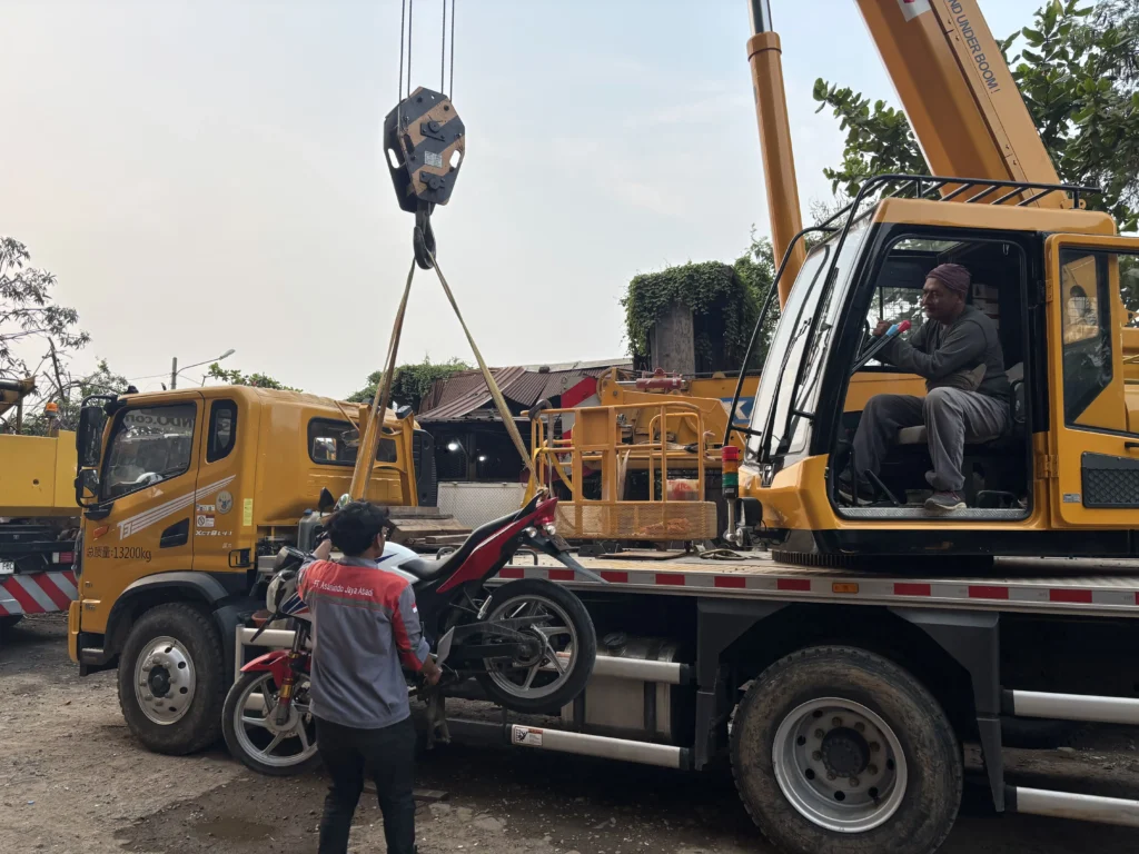  Rigger profesional sedang memasang dan memeriksa sling pada beban berat sebelum operasional lifting dimulai di lokasi proyek