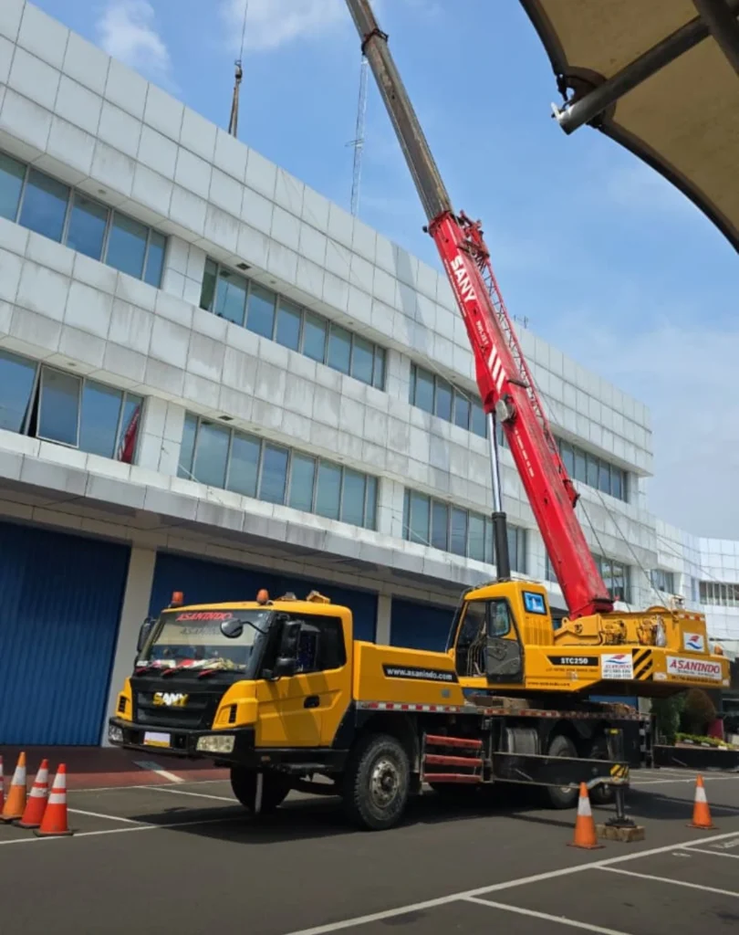 移动式起重机以高精度将生产设备吊装并精准定位至工业园区工厂生产车间的指定安装位置